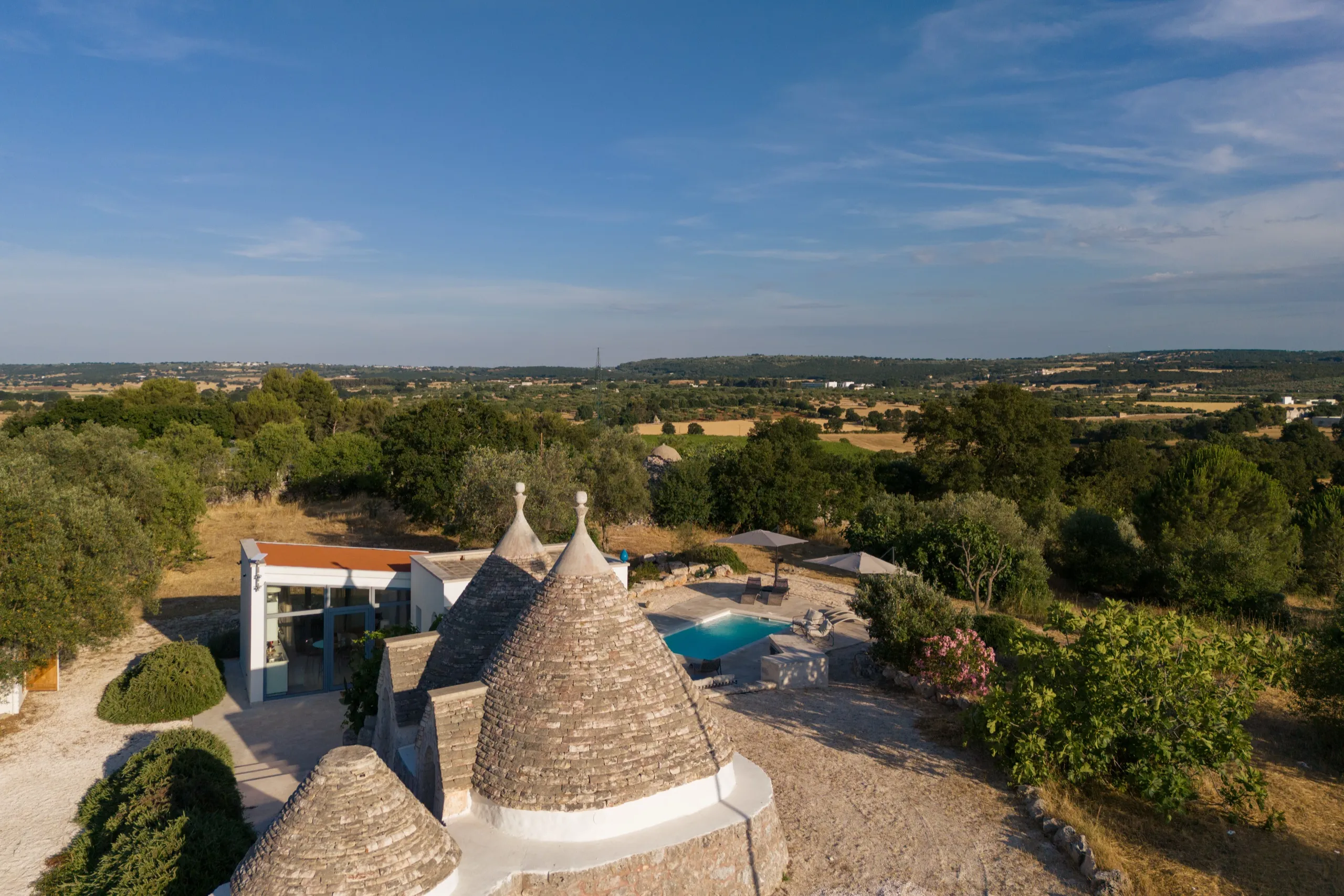Vue aérienne du trullo et de la piscine au coucher de soleil