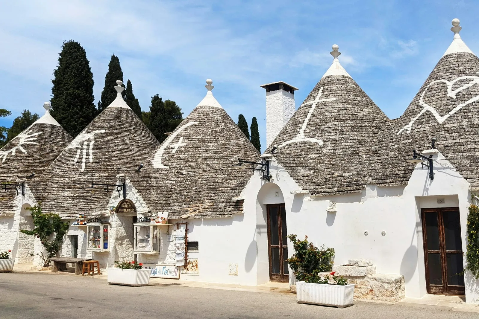 Rue de trulli aux toits ornés de symboles à Alberobello