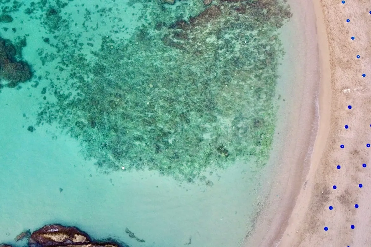 Eau turquoise et plage de Capitolo vues du ciel
