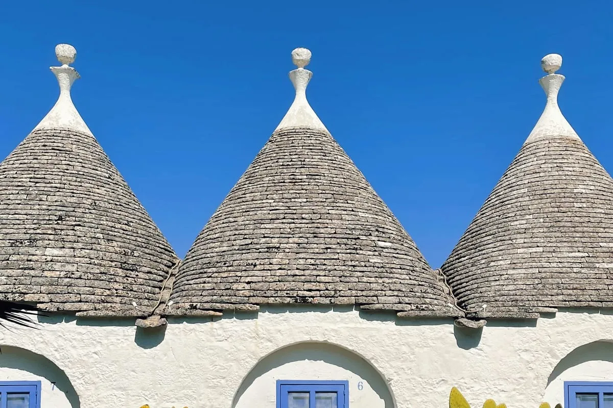 Toits coniques de trulli sous un ciel bleu à Cisternino