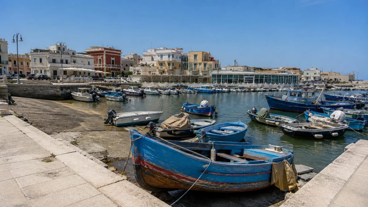 Barques de pêche bleues amarrées dans le port de Savelletri